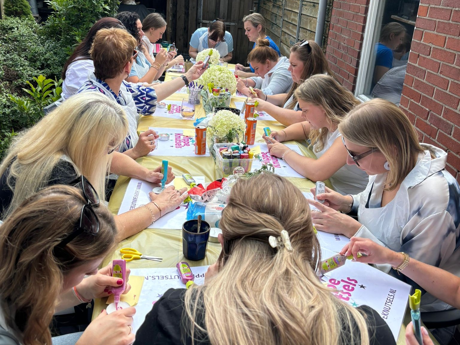Collega’s volgen een creatieve workshop op bedrijfsfeest, verzorgd door Hippe Knutsels op locatie